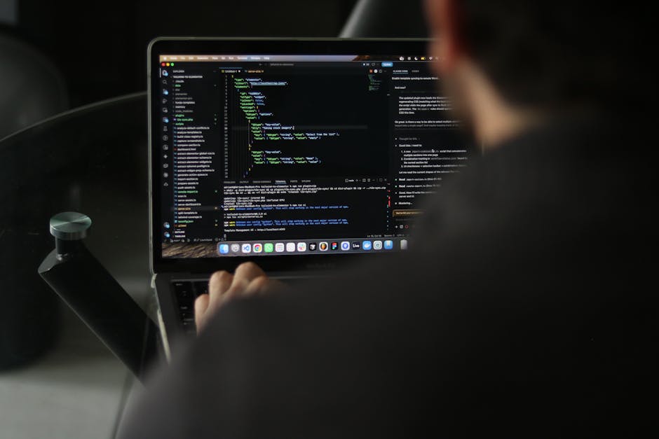 A person working on a laptop with a dark-themed code editor open, displaying lines of programming code. The individual is seated in a vehicle, with the laptop resting on their lap or a surface inside